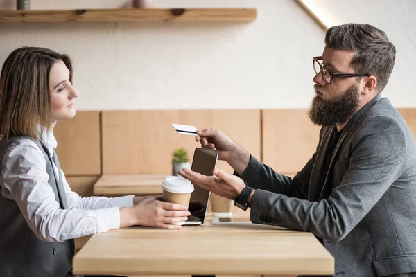 A férfi hitelkártyát ad a nőnek — Stock Fotó