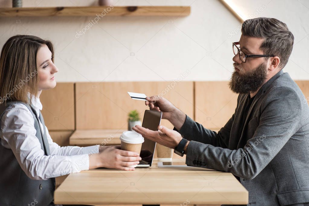 man giving credit card to woman
