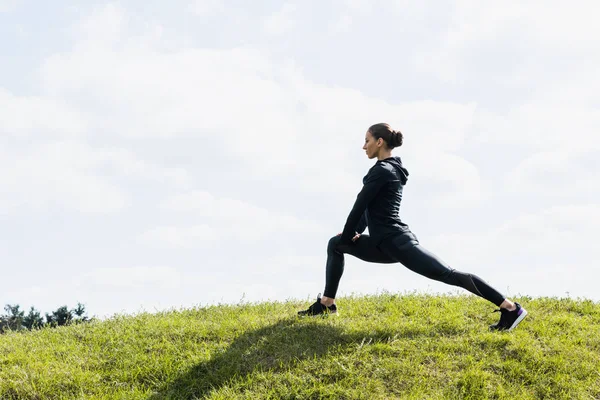 Vältränad kvinna stretching benen — Stockfoto