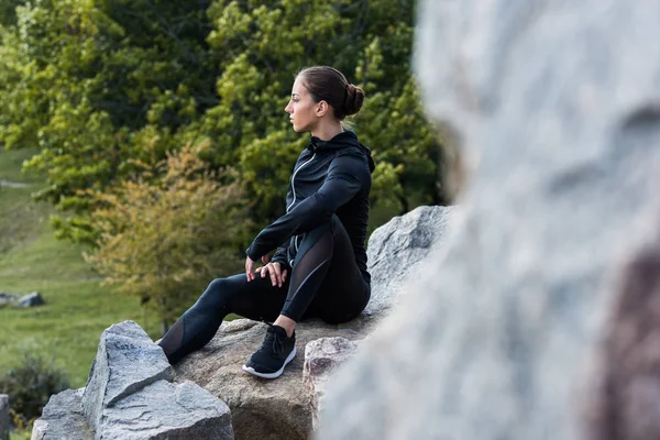 Femme assise sur des rochers — Photo gratuite