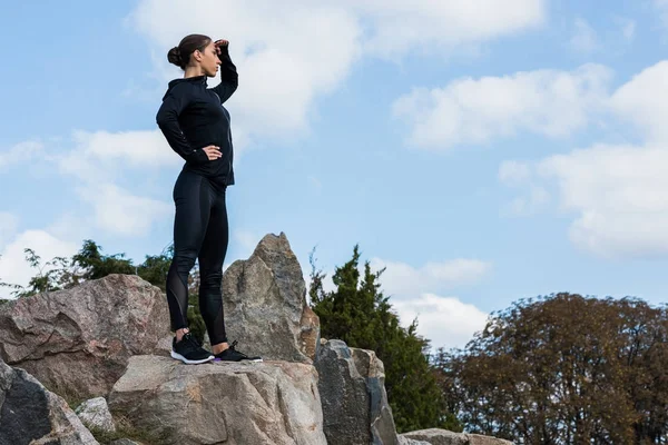 Frau steht auf Felsen und schaut weg — Stockfoto