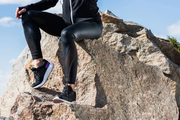 Woman sitting on rocks — Stock Photo, Image