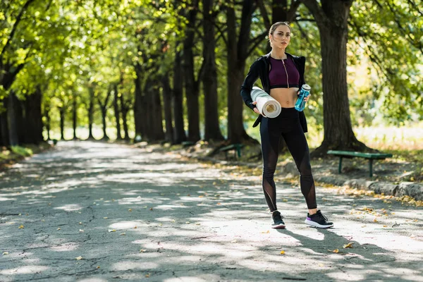 Mujer con esterilla de yoga — Foto de Stock