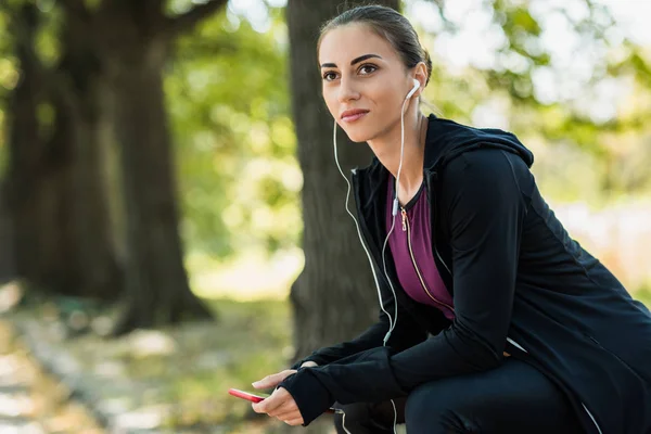 Mujer escuchando música en el parque — Foto de Stock