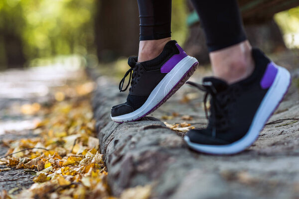 woman in sneakers at autumn park