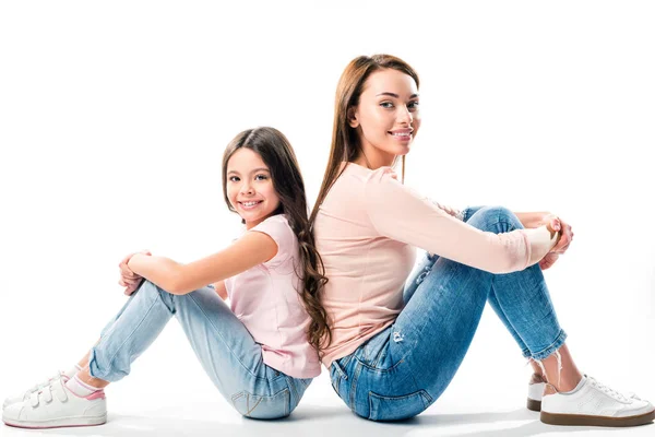 Daughter and mother sitting back to back — Stock Photo, Image