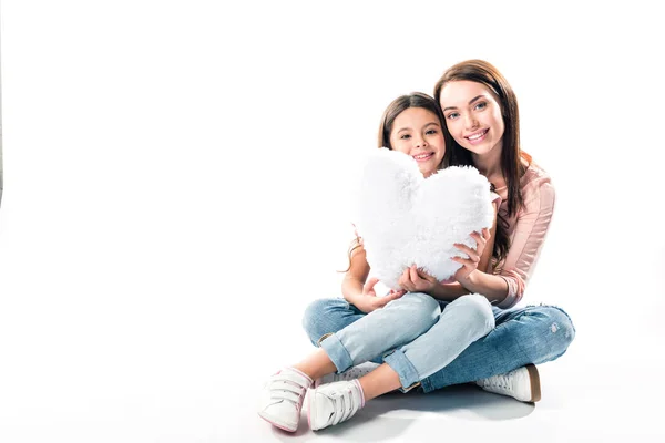 Mother and daughter with heart shaped pillow — Stock Photo, Image