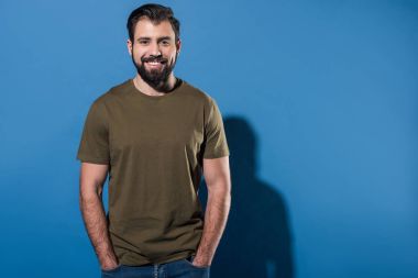 yakışıklı gülümseyen adam elleri ceplerinde mavi olan ayakta