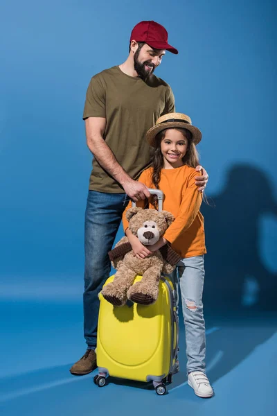 父亲和女儿站在蓝色的行李和泰迪熊 — 免费的图库照片