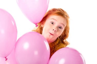 pembe balon üzerinde beyaz izole bohça ile ayakta Kızıl saçlı çocuk yapması