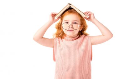 Kızıl saçlı çocuk kitap üzerinde beyaz izole kafasına