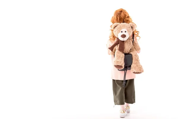 后面的红头发的孩子站在与泰迪熊背面孤立的白色 — 图库照片