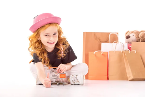 Kid Sitting Shopping Car Toy Showing Thumb White Stock Image