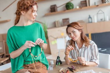 young women with handmade necklaces at workshop clipart