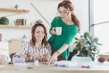 young women making accessories in handmade workshop clipart