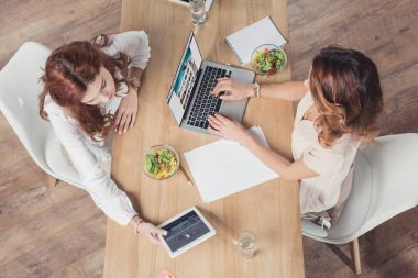 birlikte öğle yemeği ve aygıtları kullanma office genç buisnesswomen Üstten Görünüm