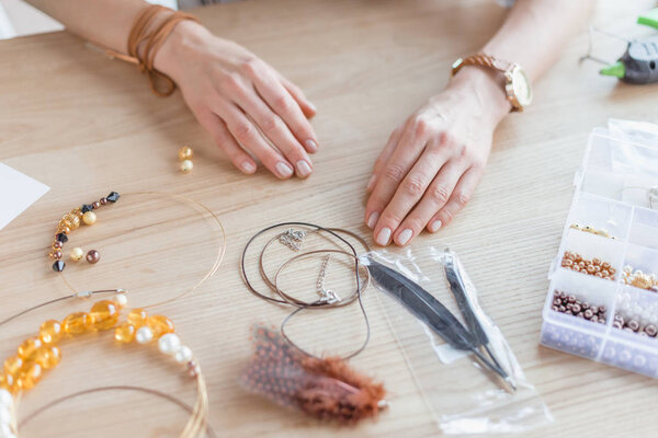 обрезанный снимок женщины с бусами и нитями для аксессуаров ручной работы в мастерской
