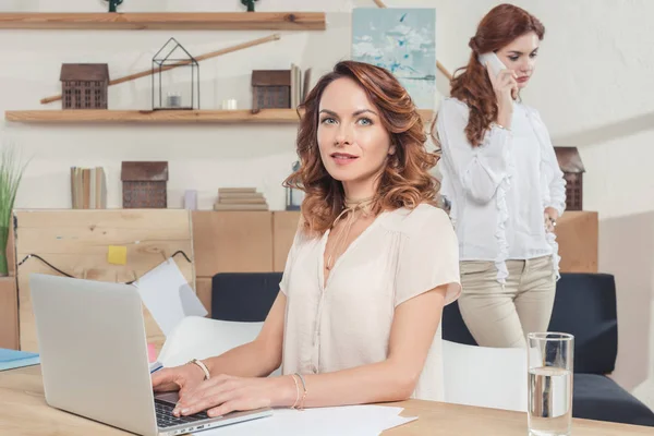 Junge Geschäftsfrau Arbeitet Mit Laptop Büro Während Ihr Kollege Telefoniert — Stockfoto