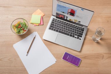 top view of workplace with laptop, smartphone and fresh salad clipart