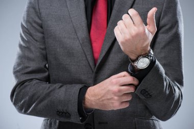 Midsection işadamı resmi kıyafetli gri izole kol düğmesini ayarlama