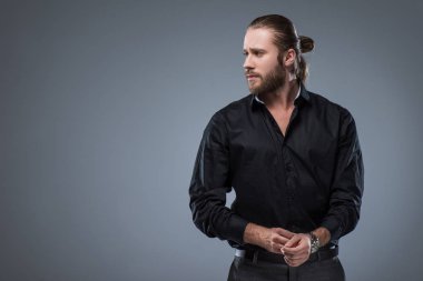 Siyah gömlek bakarak yakışıklı sakallı adam uzakta, gri izole