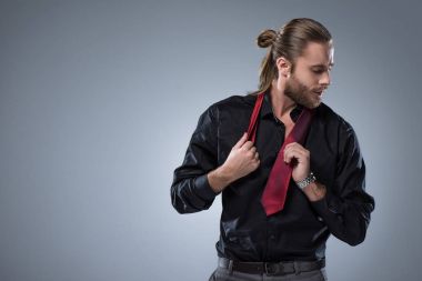 Onun boynuna gri izole kırmızı kravat ile siyah tişörtlü adam genç sakallı  