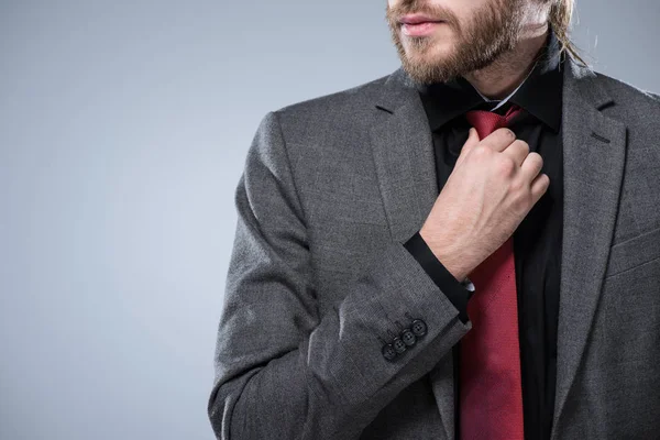 Imagem Cortada Empresário Barbudo Tocando Sua Gravata Vermelha Isolado Cinza — Fotografia de Stock