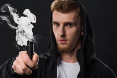 Young bearded man activating electronic cigarette clipart