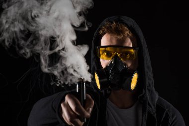 Man wearing protective filter mask activating electronic cigarette clipart