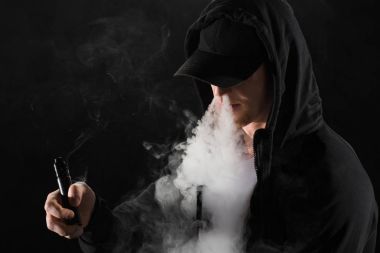 Genç adam elektronik sigara buhar bulutlar tarafından çevrili duman exhaling sakallı