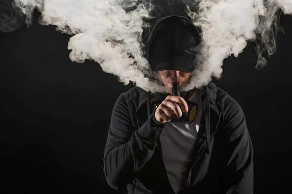 Jovem Barbudo Vestindo Tampa Exalando Fumaça Cigarro Eletrônico Isolado Preto — Fotografia de Stock