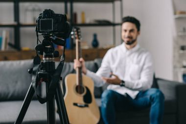 müzik blogger holding ve akustik gitar açıklayan