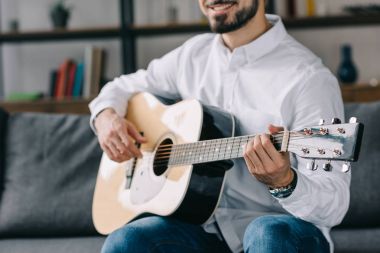 kırpılmış görüntü gülümseyen müzisyen akustik gitar çalmak