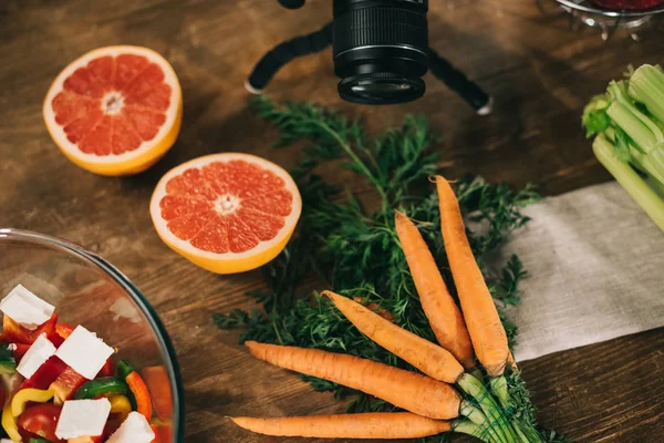 桌上有数码相机的柚子和胡萝卜 — 图库照片