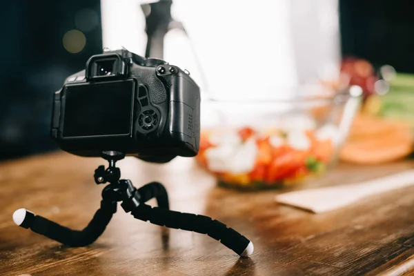 Digitalkamera Auf Dem Tisch Mit Salat Auf Verschwommenem Hintergrund — Stockfoto