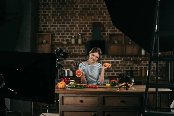 Smiling young food blogger holding halves of grapefruit in hands — Stock Image Smiling Young Food Blogger Holding Halves Grapefruit Hands Royalty Free Stock Images