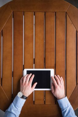 tablet kullanma ve masada oturan insanın Resim kırpılmış