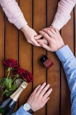 cropped image of boyfriend proposing girlfriend and holding her hand clipart