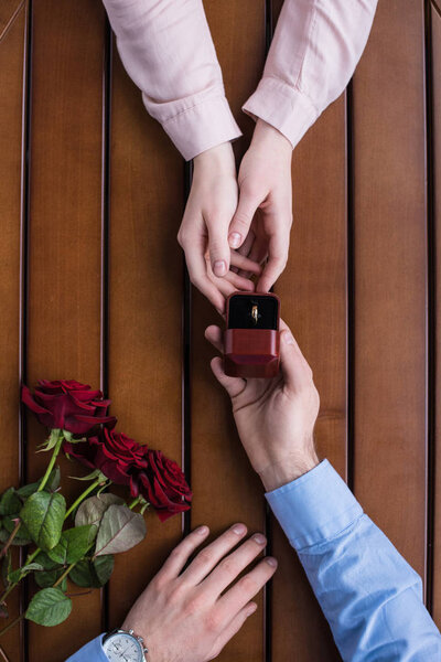 cropped image of boyfriend proposing girlfriend and holding wedding ring