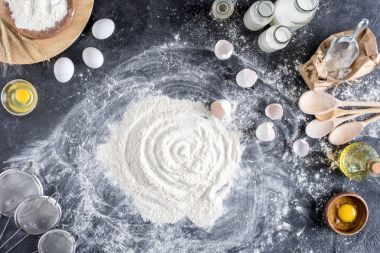 düz lay un ve ekmek, karanlık masa üzerinde ahşap mutfak eşyaları için diğer malzemeler ile