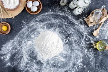 düz lay un ve ekmek, karanlık masa üzerinde mutfak eşyaları için diğer malzemeler ile