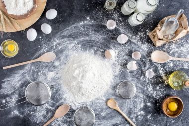 düz lay un ve ekmek, karanlık masa üzerinde ahşap mutfak eşyaları için diğer malzemeler ile