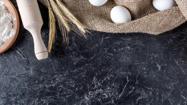 Επίπεδη Lay Σιτάρι Ωμά Αυγά Τσουβαλόπανο Και Ξύλινο Πλάστη Σκούρο — Φωτογραφία Αρχείου