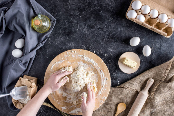 cropped shot of woman mixing ingredients and kneading dough for bread