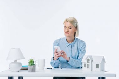 Emlakçı ile ev modeli işyerinde smartphone kullanarak portresi
