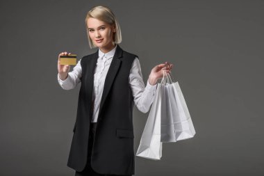 şık ve kadın ile kredi kartı alışveriş torbaları gri izole portresi