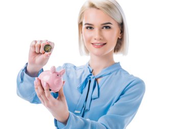 portrait of smiling businesswoman with piggy bank and coin in hands isolated on white clipart