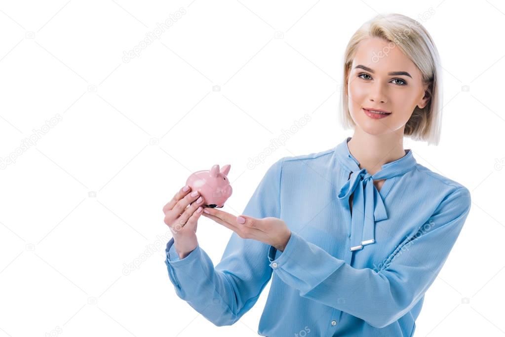 portrait of smiling businesswoman showing piggy bank isolated on white 