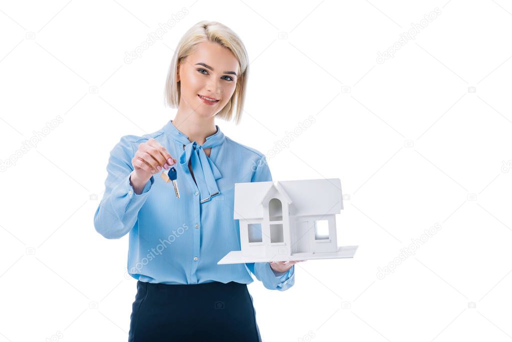beautiful smiling realtor holding key and house model, isolated on white