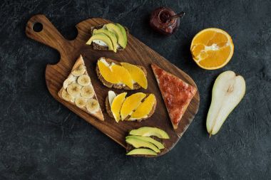 düz lay aperatifler için karanlık masa üzerinde ahşap kesme tahtası üzerinde sağlıklı kahvaltı ile